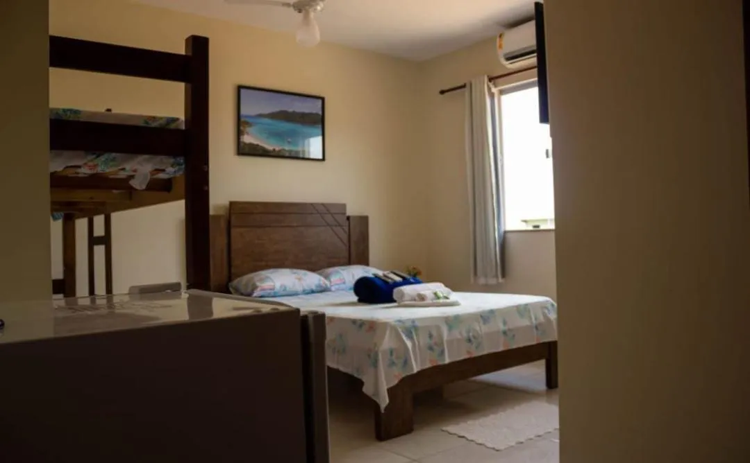 Quarto da pousada com cama de casal, beliche, ar-condicionado e janela